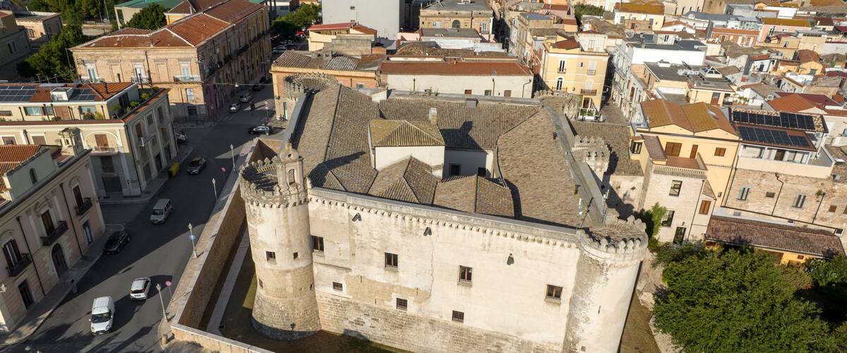 An aerial view of a historic castle surrounded by urban buildings.