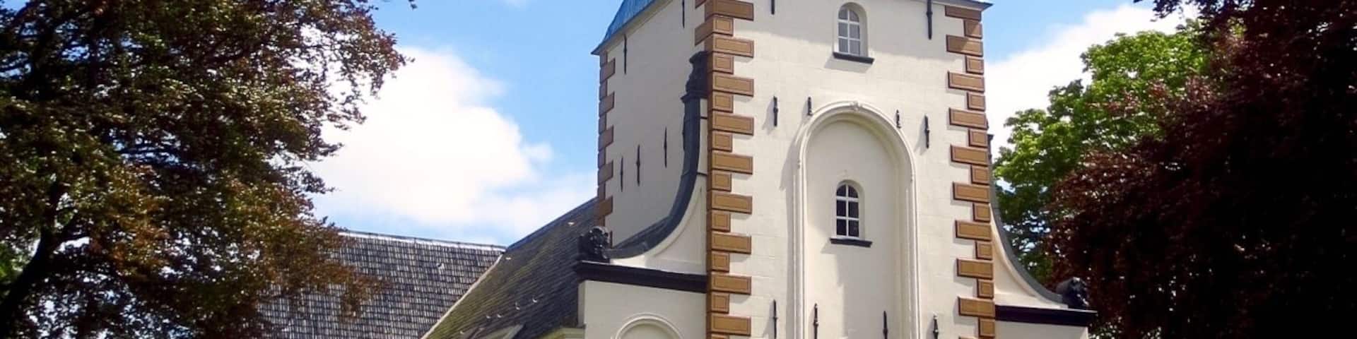 A church with a tall bell tower, blue dome, and white walls.