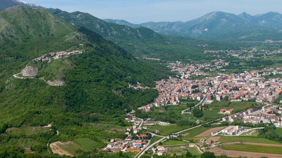 A town nestled in a valley surrounded by mountains.