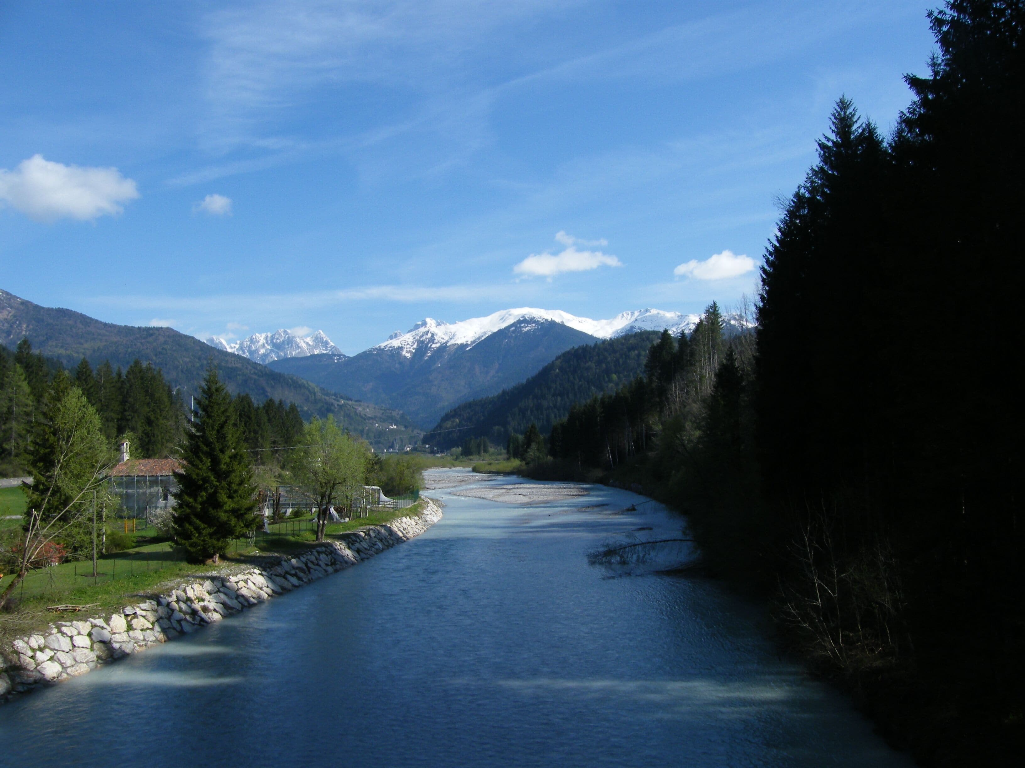 A river flowing through a valley with mountains in the background.