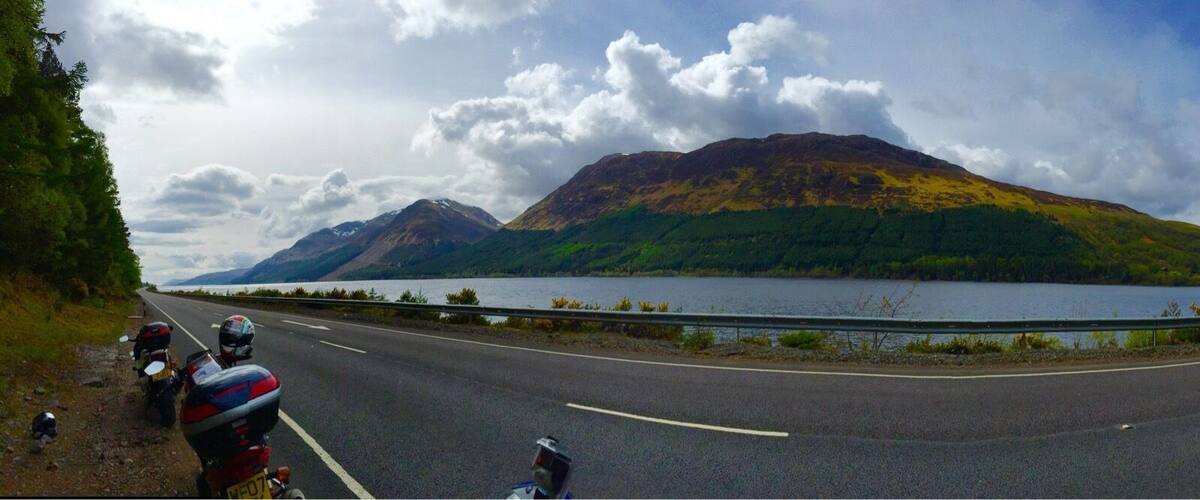 A road with a mountain in the background and a lake.