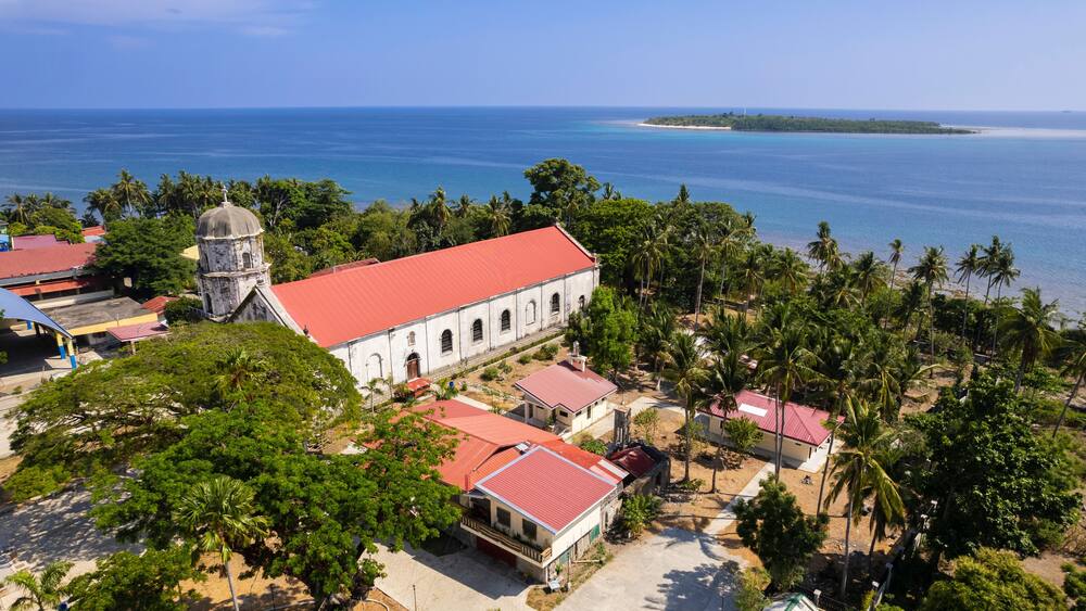 Aerial Anini-y Church or the Parish Church of San Juan Nepomuceno, and the nearby Nogas Island.