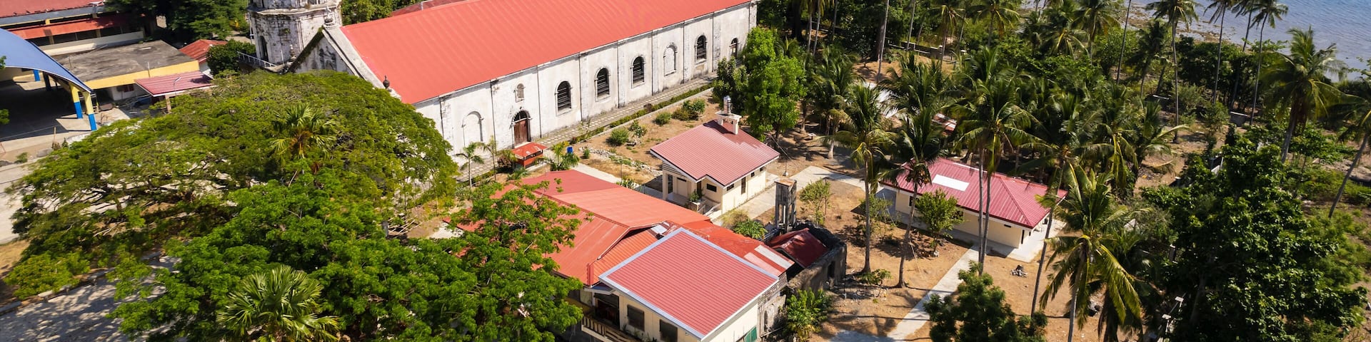 Aerial Anini-y Church or the Parish Church of San Juan Nepomuceno, and the nearby Nogas Island.