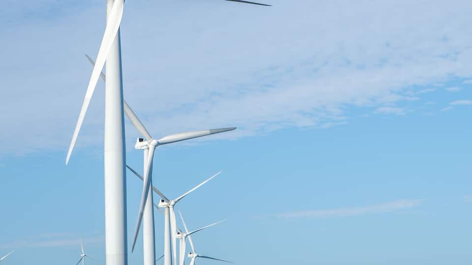 A coastal landscape with multiple wind turbines.