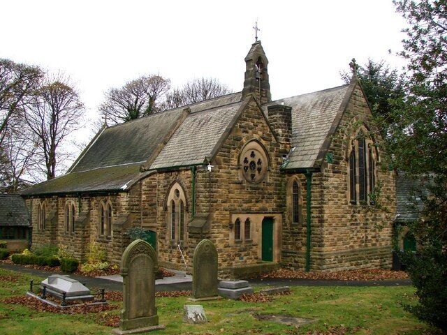 A stone church with a pointed roof and a bell tower.