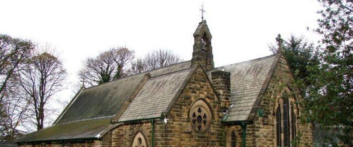 A stone church with a pointed roof and a bell tower.