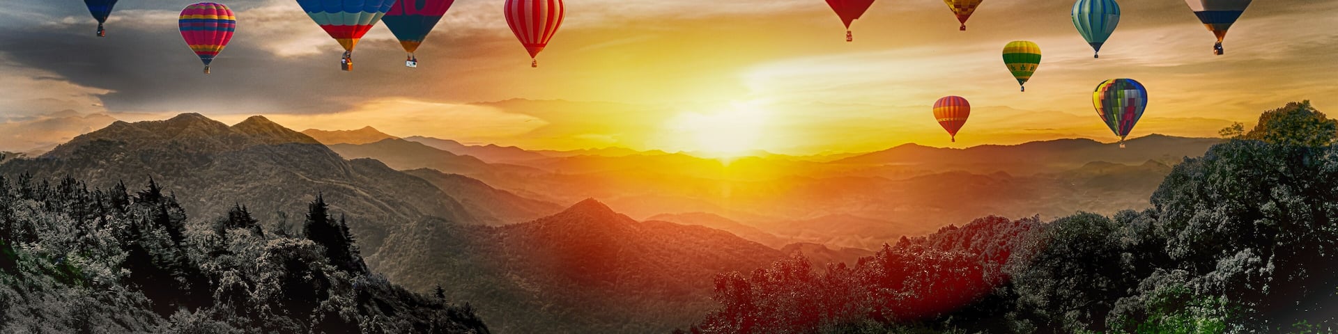 Dramatic panorama of mountain with hot air balloons at sunset,Thailand.