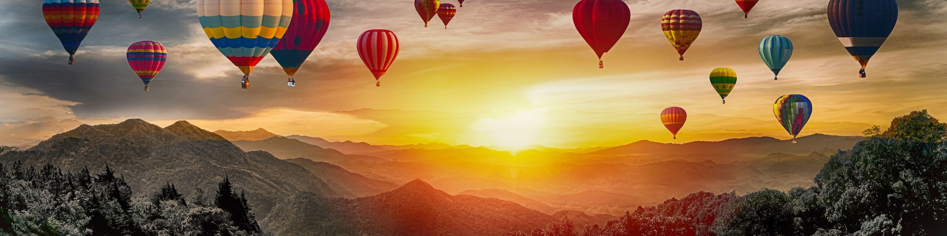 Dramatic panorama of mountain with hot air balloons at sunset,Thailand.