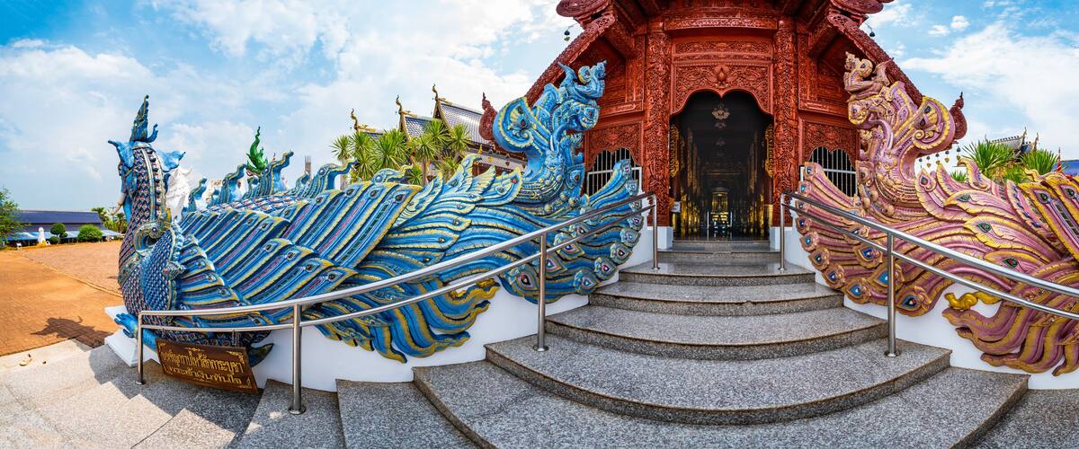 A temple with intricate blue and pink decorations and a staircase leading to the entrance.