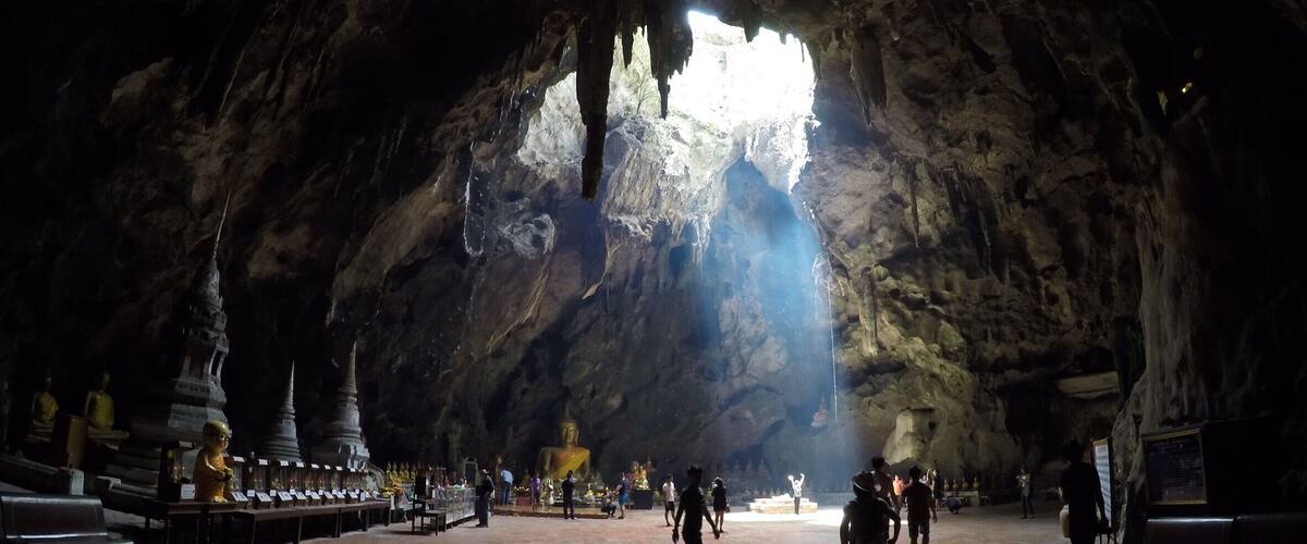 A cave temple with a large Buddha statue and smaller statues.