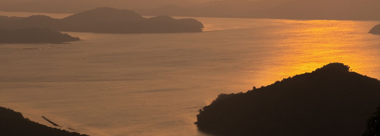 Atardecer sobre un cuerpo de agua tranquilo con varias islas.