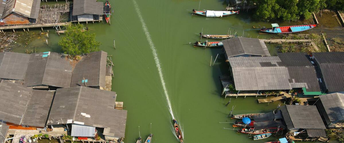 A river with boats and floating houses.