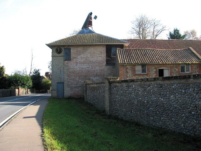 The maltings. The now disused brewery was built in 1783 by William Hardy from East Dereham, who conducted his business as a maltster from Coltishall, using his own wherry for the transport of goods. After moving to Letheringsett Hall > 1025717 with his family in 1781, he purchased the maltings and Hagan's brewery, situated across the road from the Hall, and there built the Letheringsett Brewery, originally constructed to function as a malt mill. The maltings are built from gault brick with some flint and have a hipped roof. Later a new mill was built within the existing main building and the first wheat ground here was sold in December 1784. Part of the complex is presently used for general storage.