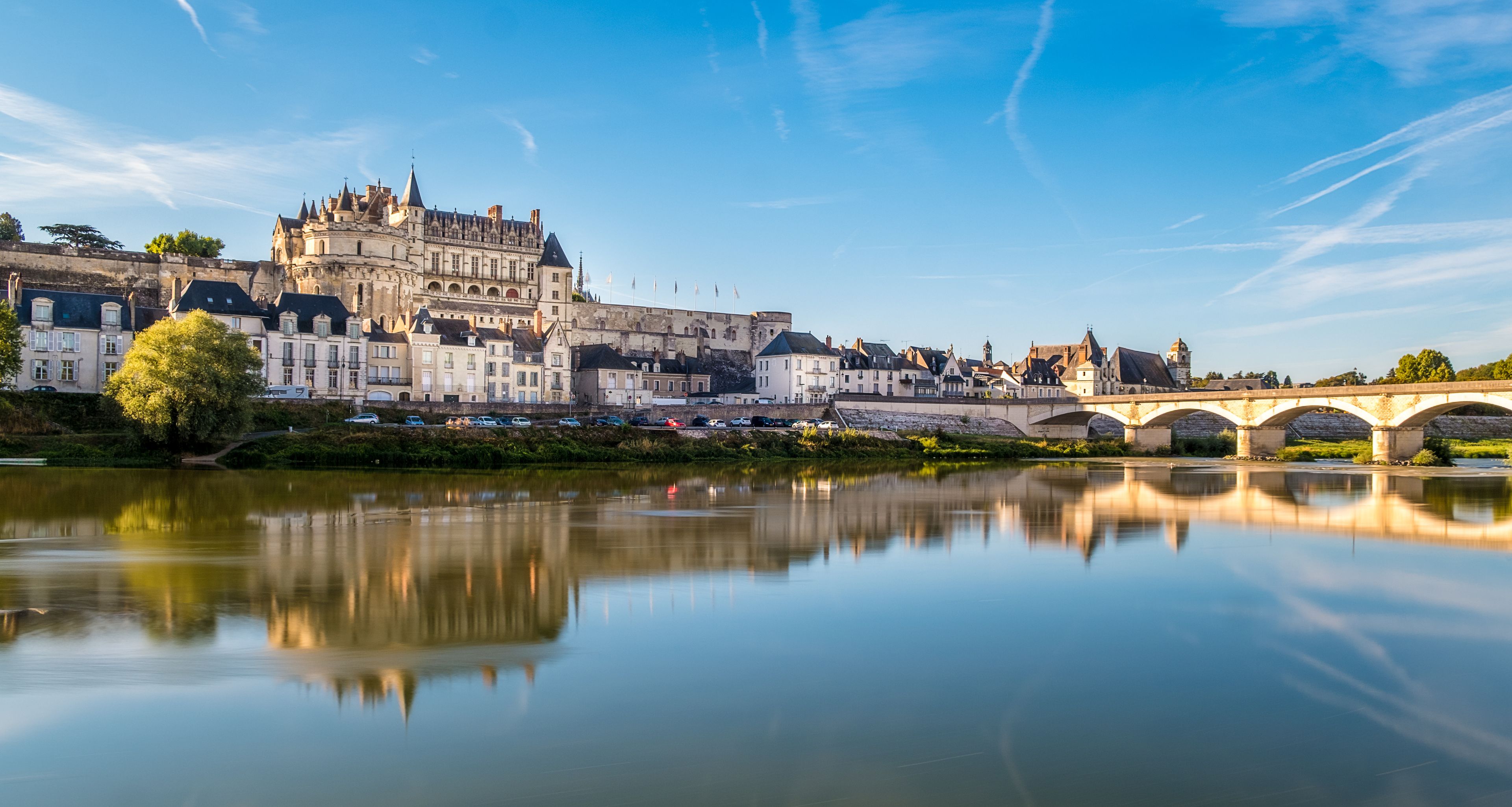 Un château historique, une rivière et un pont de pierre.
