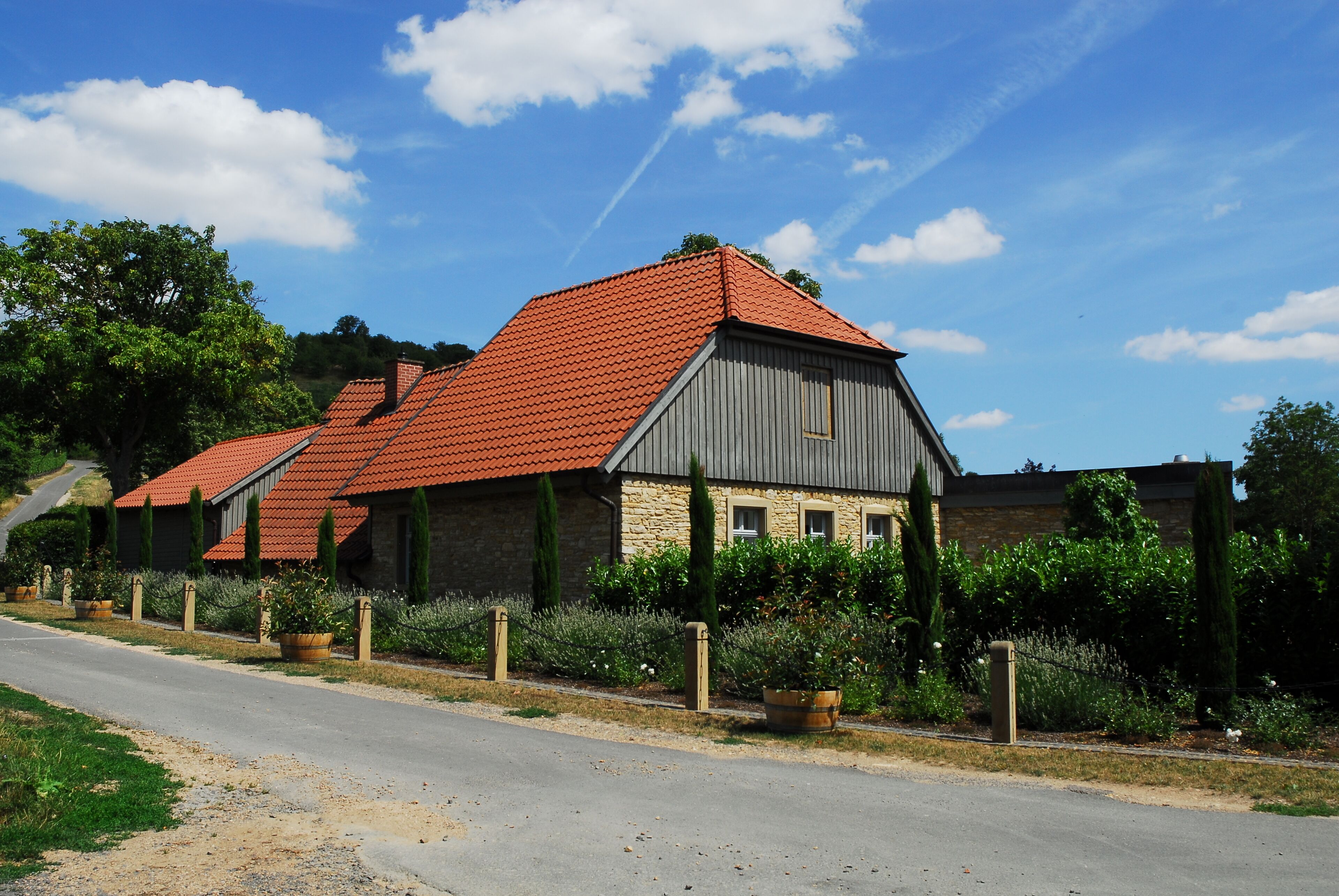 A row of stone houses with red-tiled roofs and a clear blue sky.