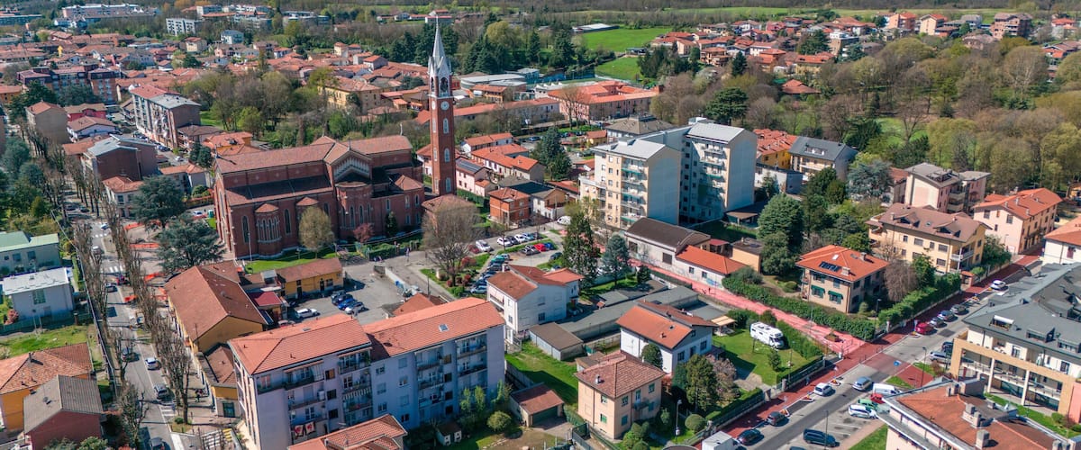 A town with a prominent church, residential buildings, and a mix of greenery.