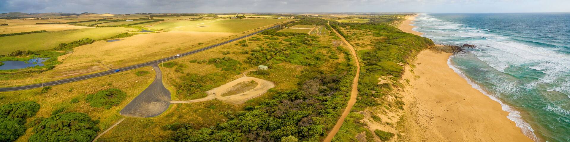 Beautiful Aerial panorama of rural area with highway and ocean coastline under fluffy clouds