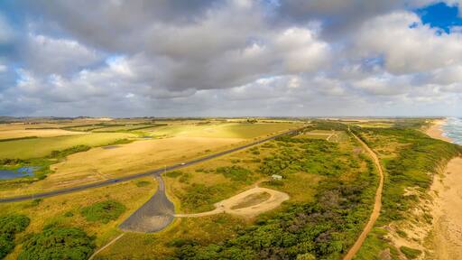 Beautiful Aerial panorama of rural area with highway and ocean coastline under fluffy clouds