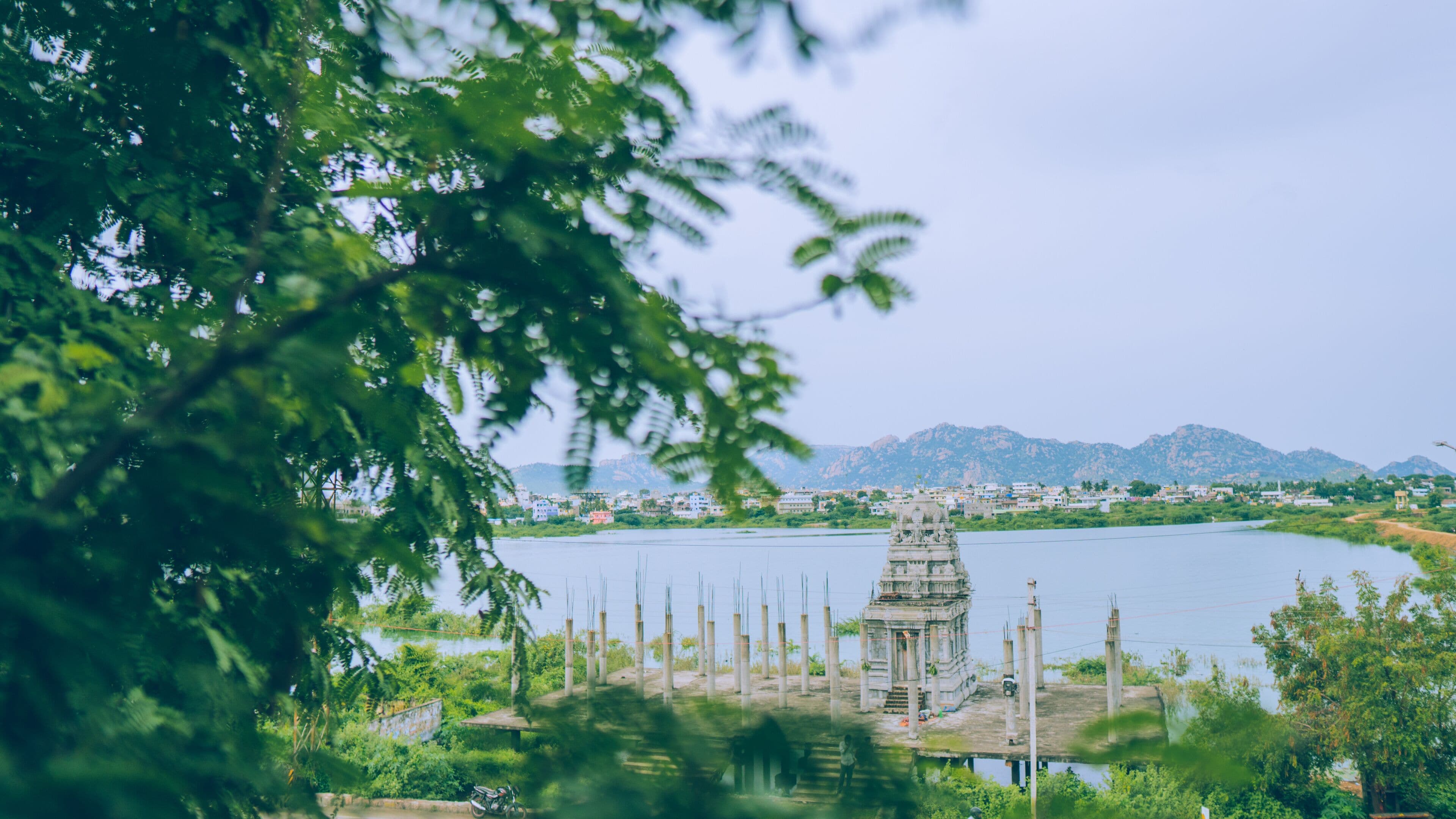 A temple by a lake with mountains in the background.