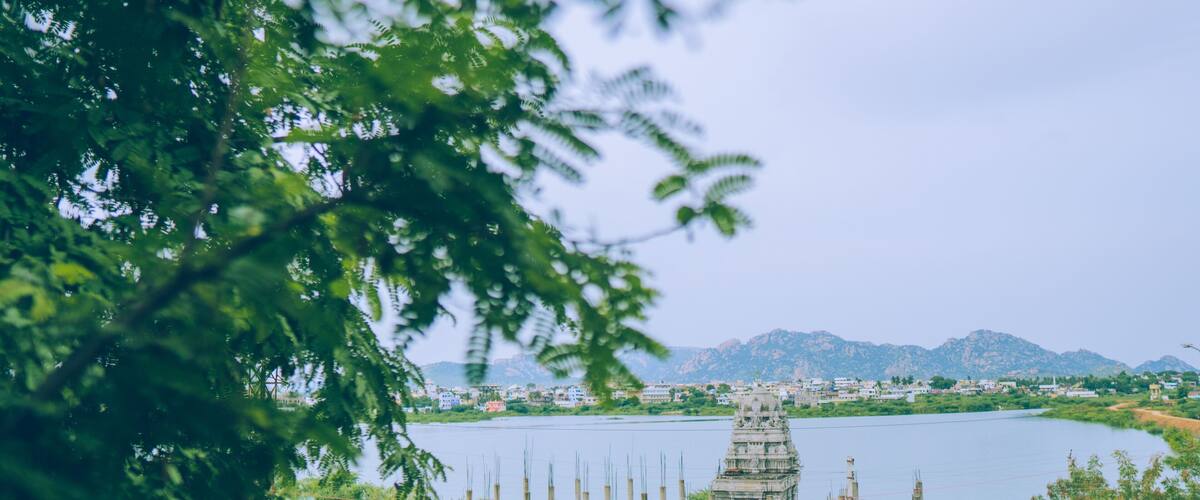 A temple by a lake with mountains in the background.
