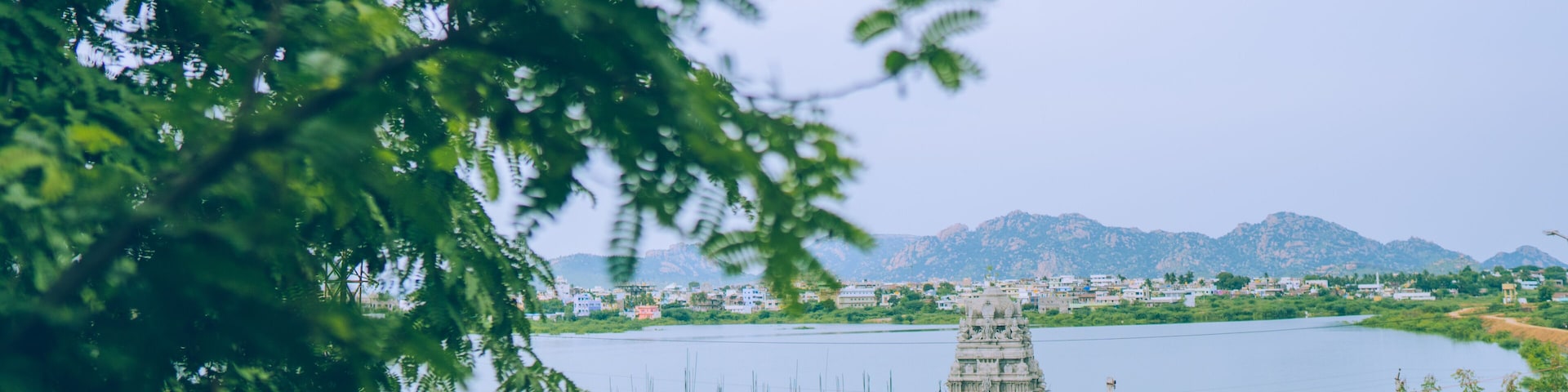 A temple by a lake with mountains in the background.