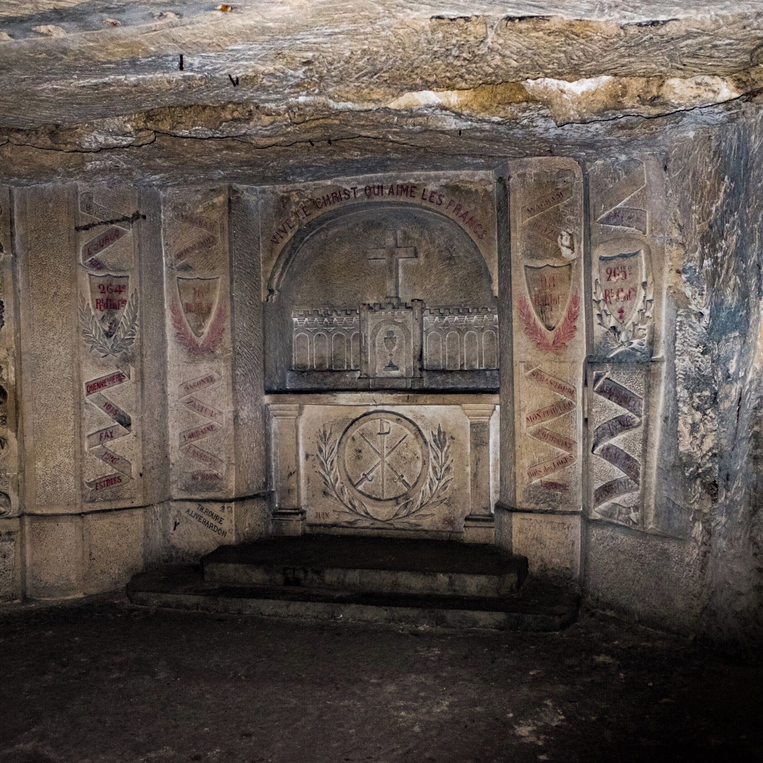 A stone chapel with religious carvings and inscriptions.