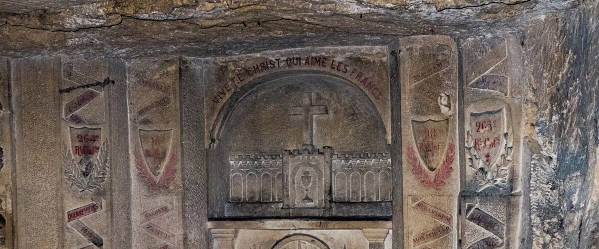 A stone chapel with religious carvings and inscriptions.