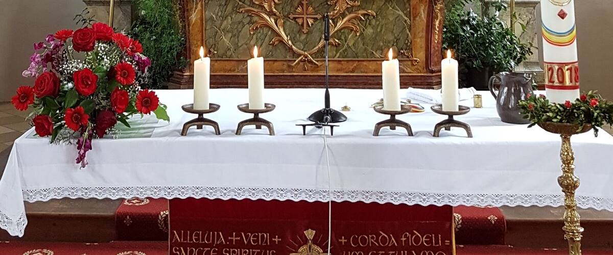 An ornate church altar with a crucifix, statues, and candles.