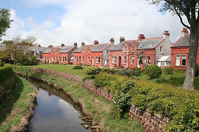 Houses at Powfoot These at Powfoot really are of a startling shade of red sandstone. In the foreground is the Pow Water.