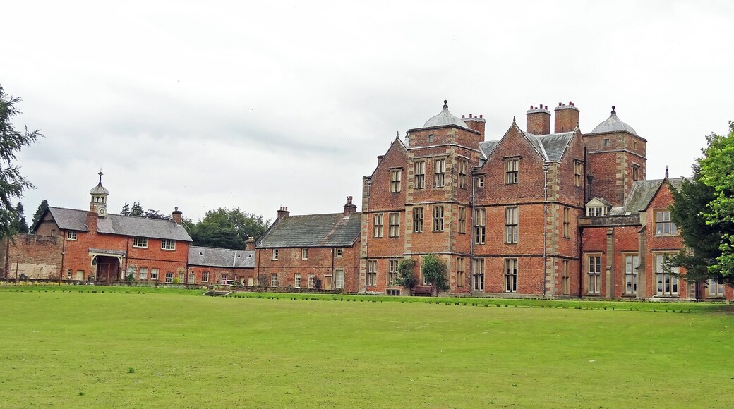 a general view of the back of the Grade I listed Kiplin Hall from beside the lake