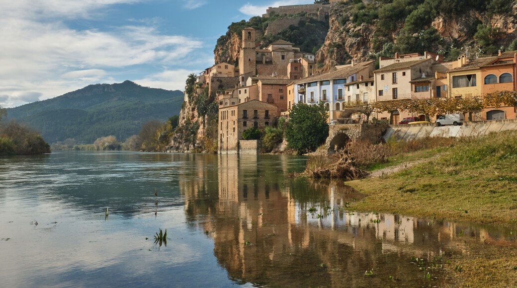 Une ville riveraine dotée de bâtiments historiques, d’une église remarquable et bordée par une montagne en arrière-plan.