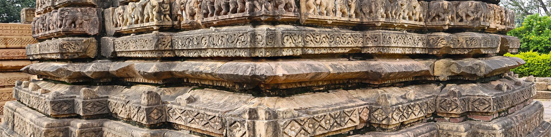 A multi-tiered stone structure with intricate carvings of figures and patterns.