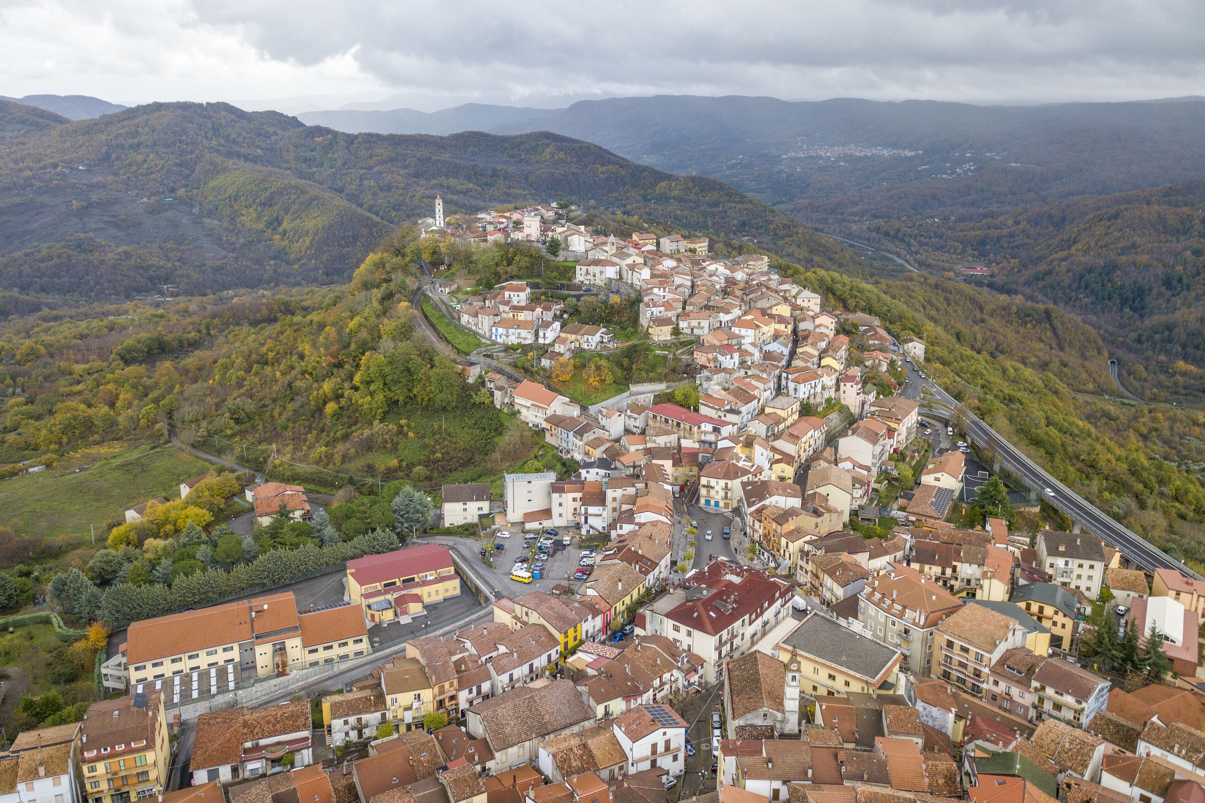 A town nestled in a valley surrounded by hills, with a prominent church tower visible.