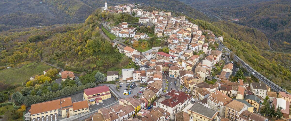A town nestled in a valley surrounded by hills, with a prominent church tower visible.
