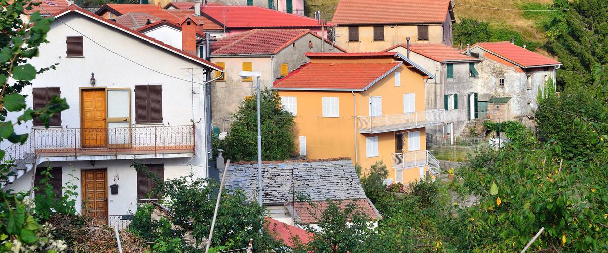 A cluster of colorful houses with red roofs nestled in a hillside village.