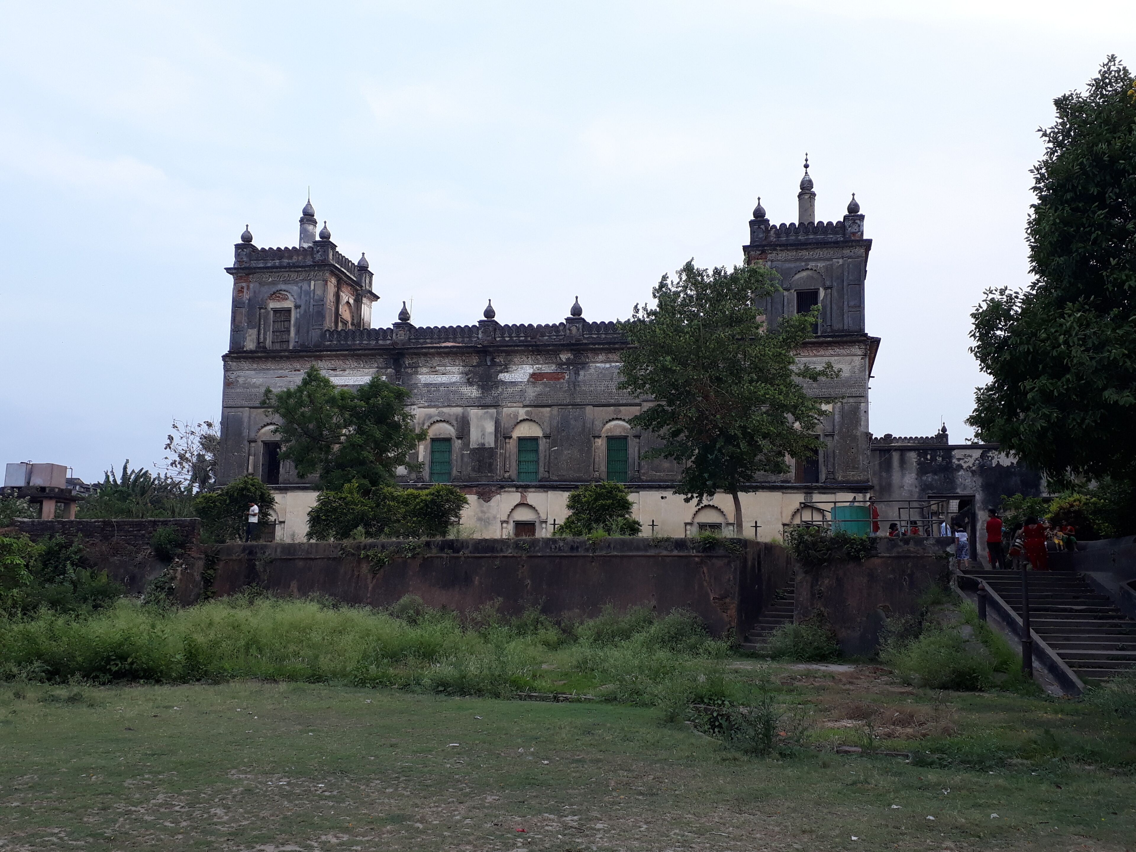 An old, ornate building with multiple towers and green doors.