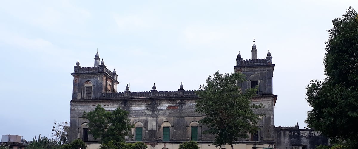 An old, ornate building with multiple towers and green doors.