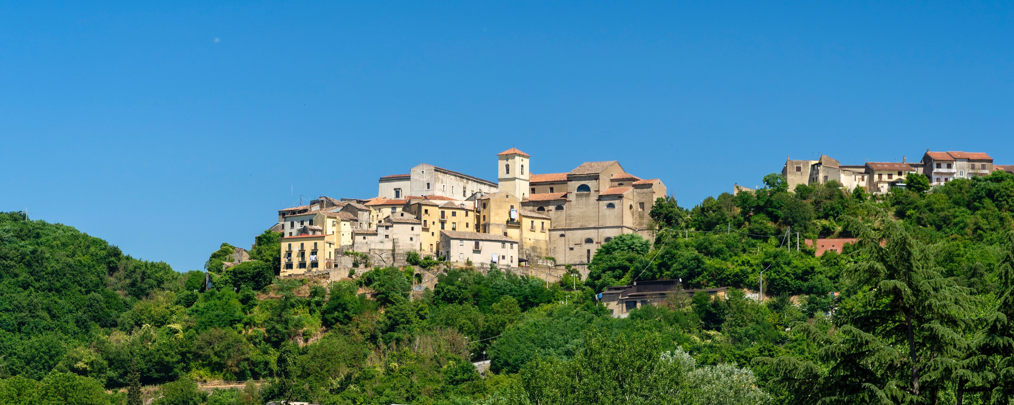 A hillside town with historic buildings and a prominent church tower.