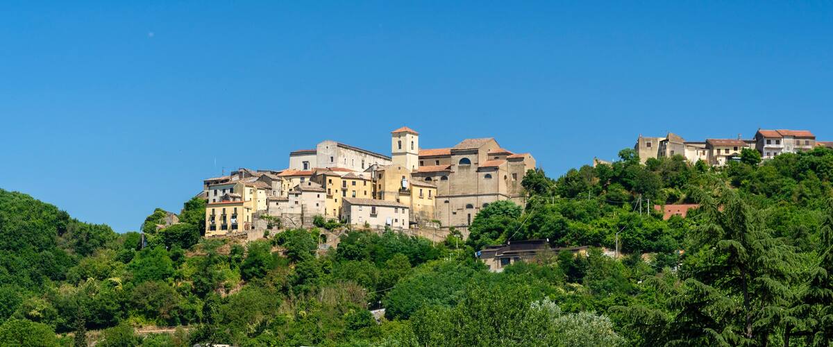 A hillside town with historic buildings and a prominent church tower.