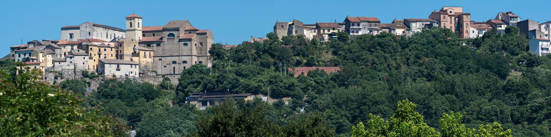 A hillside village with historic buildings and lush greenery.