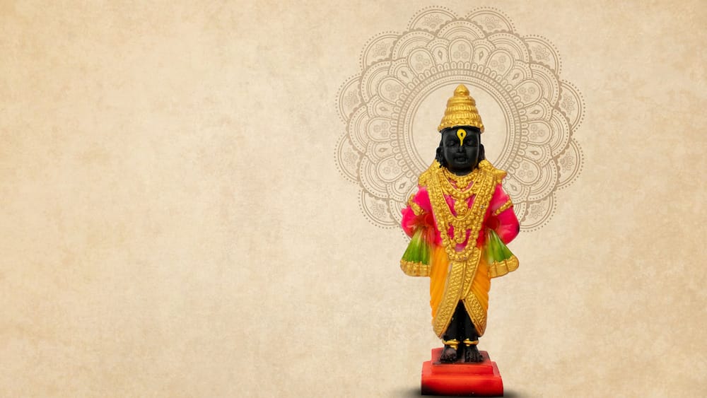 A statue of a deity with a golden headdress and a red base.