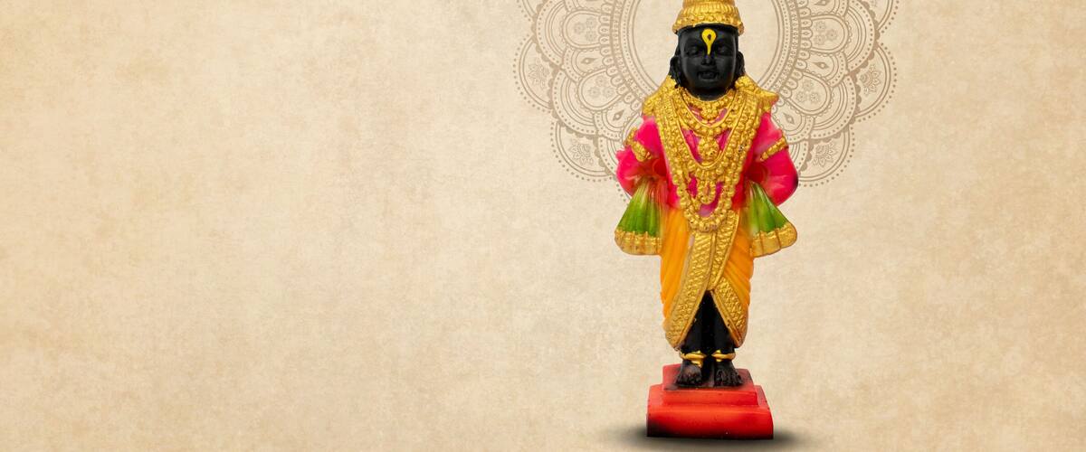 A statue of a deity with a golden headdress and a red base.