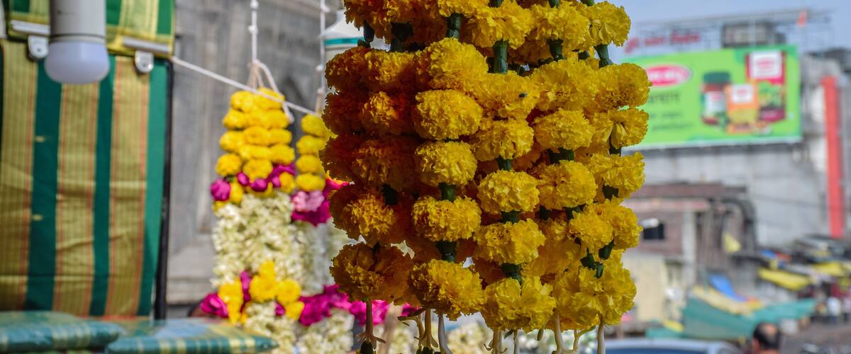 A street market with a large display of yellow marigold flowers.