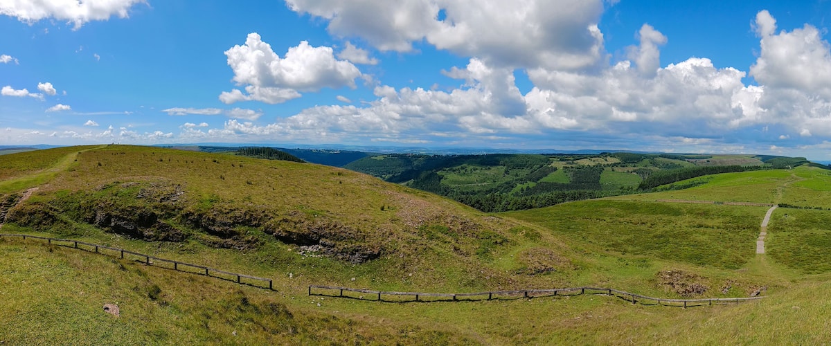 Rolling hills, a fenced path, and a distant town.
