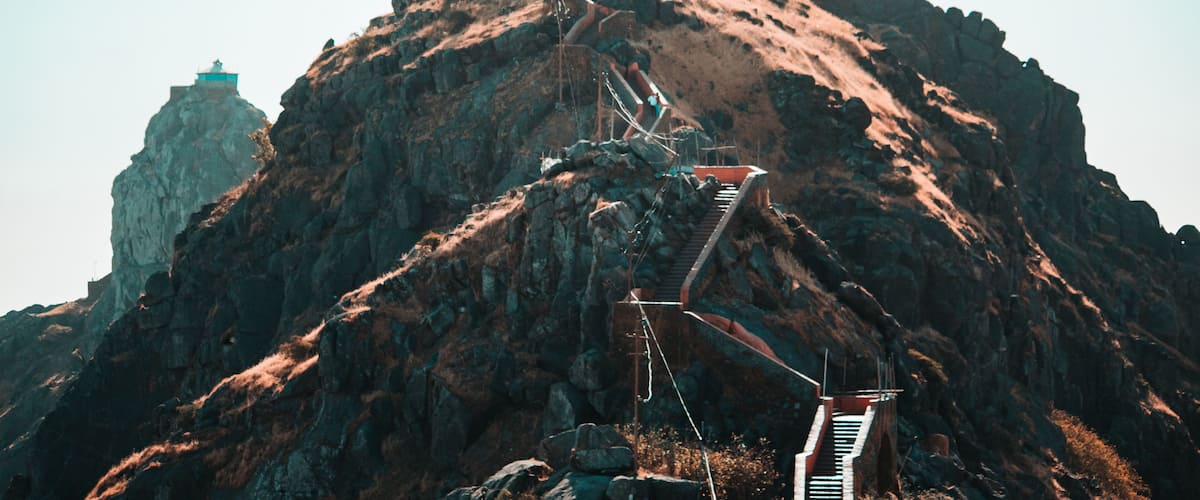 A mountain with a staircase leading to a viewing platform.