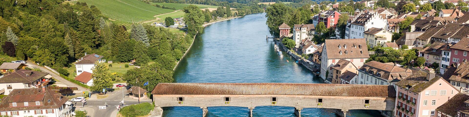 Aerial image the old wooden covered bridge over the Rhine river, which connects the Swiss old town Diessenhofen and German town Gailingen.