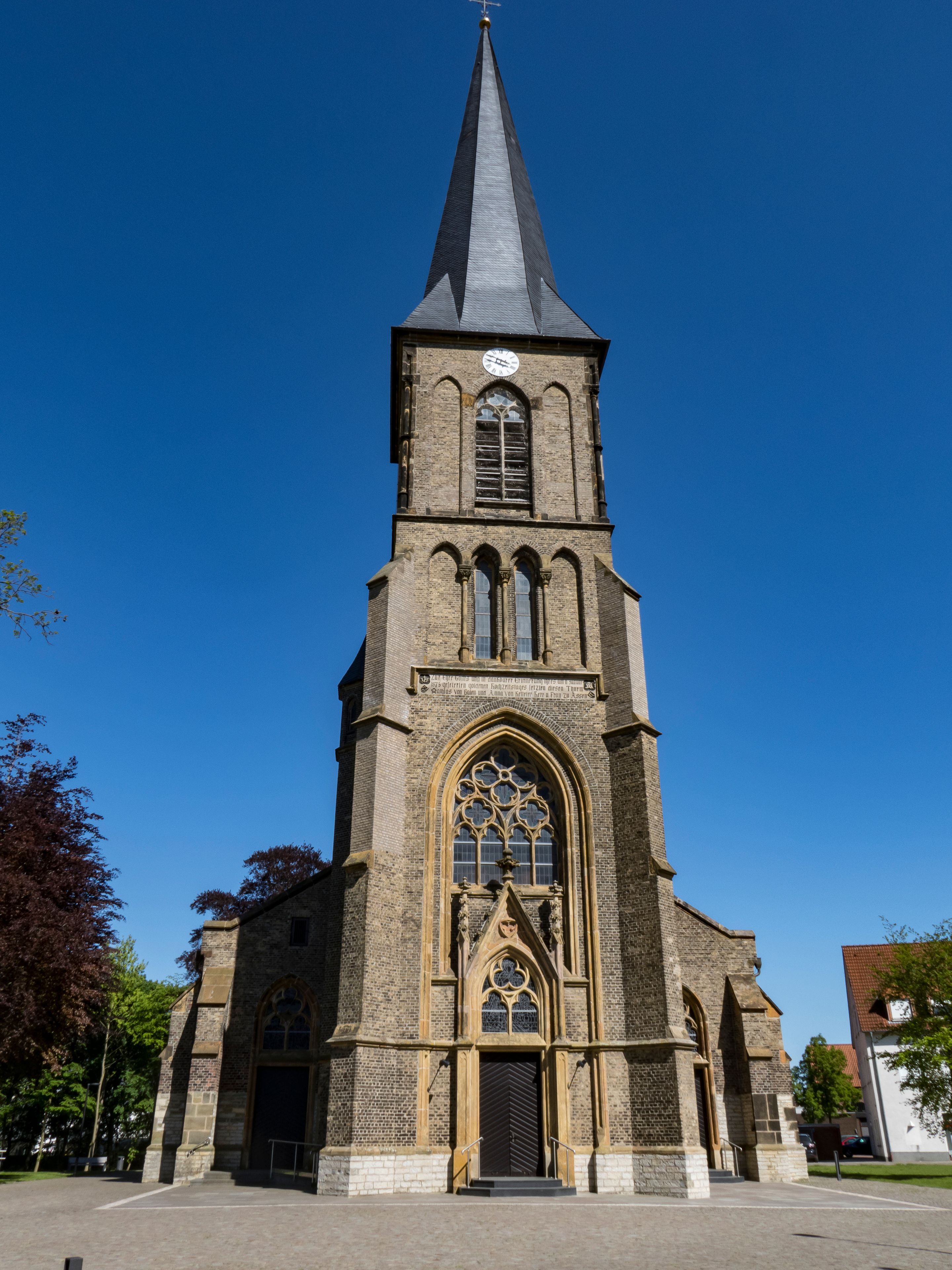 Eine Kirche mit einem hohen Turm, einem großen Bogenfenster und einer Uhr.