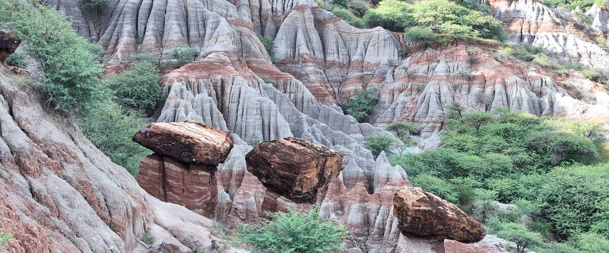 A rugged landscape with eroded rock formations and scattered boulders.