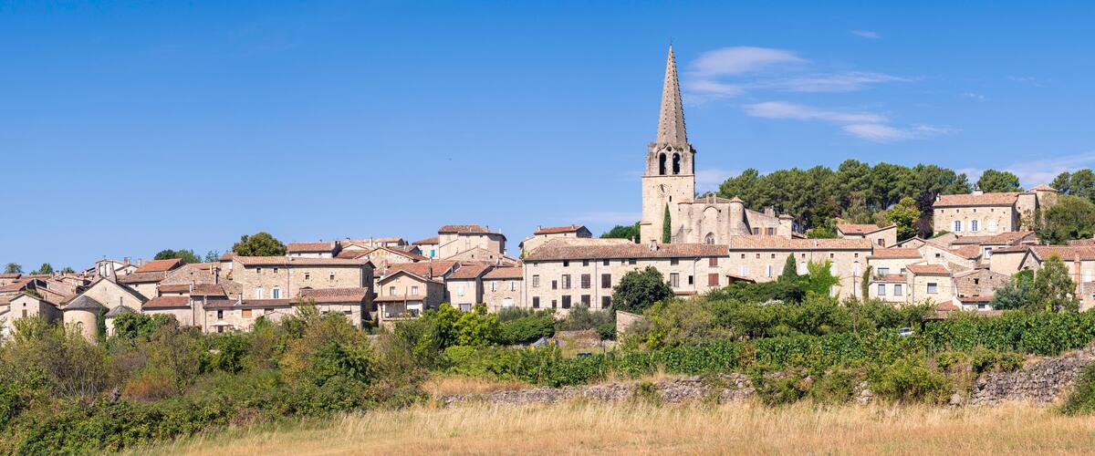 A historic town with a prominent church tower and surrounding stone buildings.