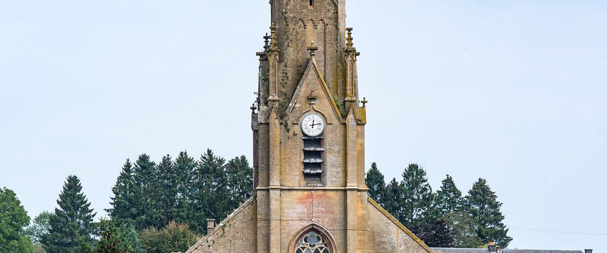 A church with a tall spire and a clock tower.